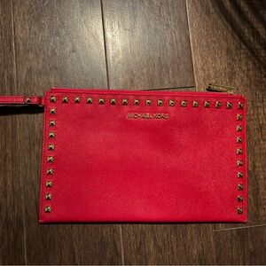 Michael Kors red wristlet with gold studded hardware.